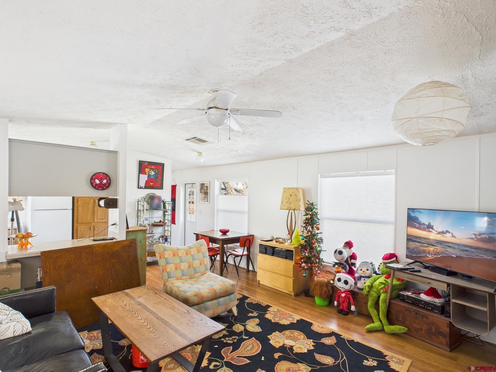 288 Animas View Drive, Unit 9 Durango, CO 81301 - Photo 3 of 20 a living room with furniture a chandelier and a flat screen tv