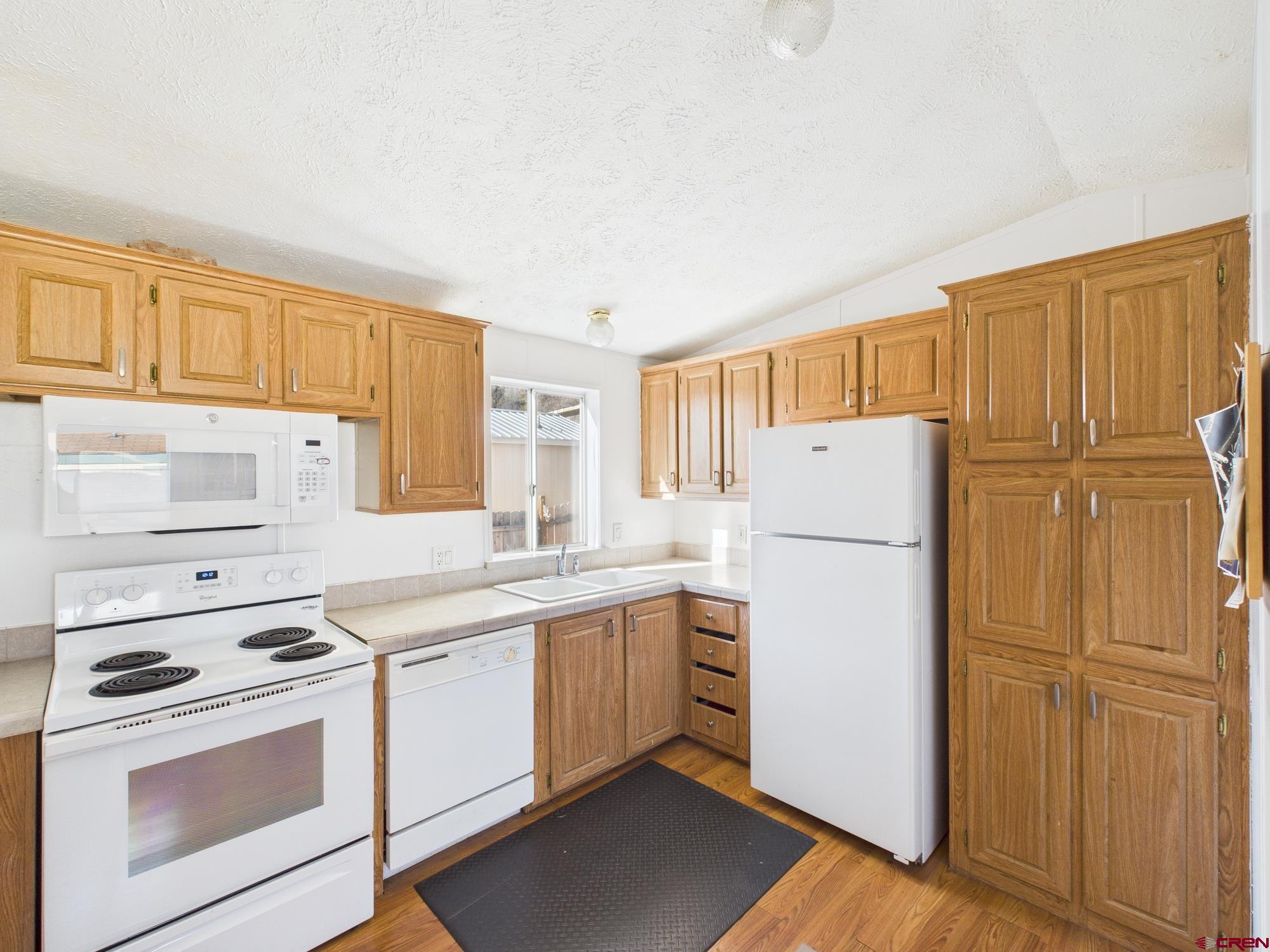 288 Animas View Drive, Unit 9 Durango, CO 81301 - Photo 9 of 20 a kitchen with a refrigerator sink stove and cabinets