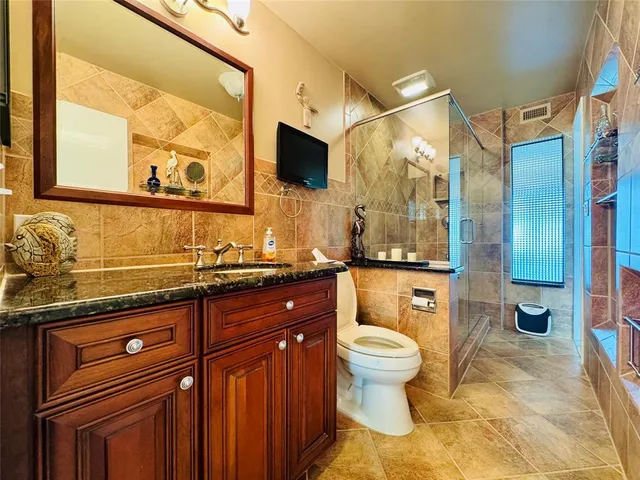 a bathroom with a granite countertop sink toilet and shower