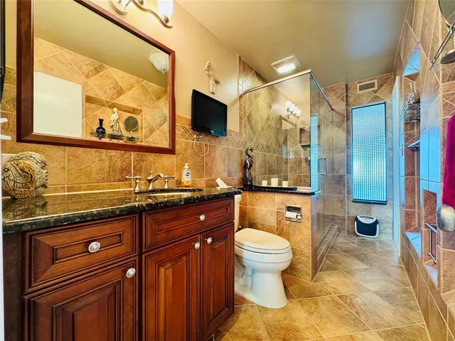a spacious bathroom with a granite countertop sink toilet and shower