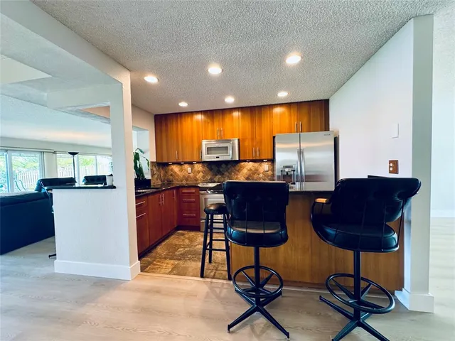 a living room with furniture a rug and kitchen view