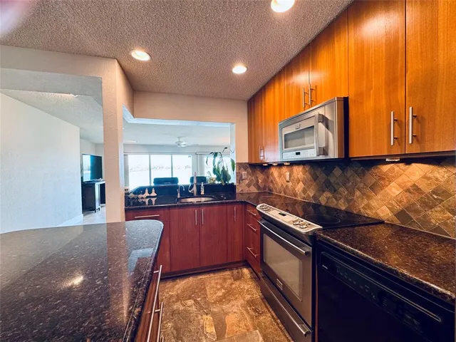 a kitchen with stainless steel appliances granite countertop sink stove and microwave