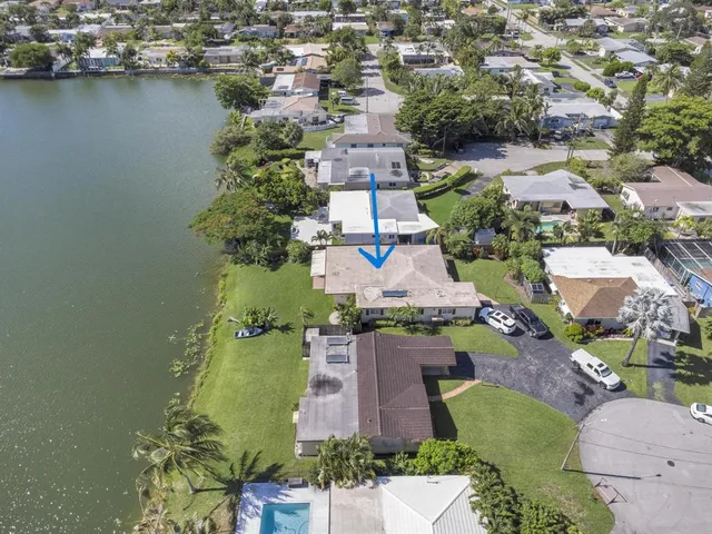 an aerial view of residential houses with outdoor space and parking