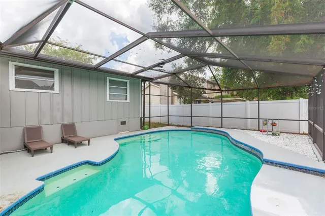 a living room with patio furniture and a floor to ceiling window