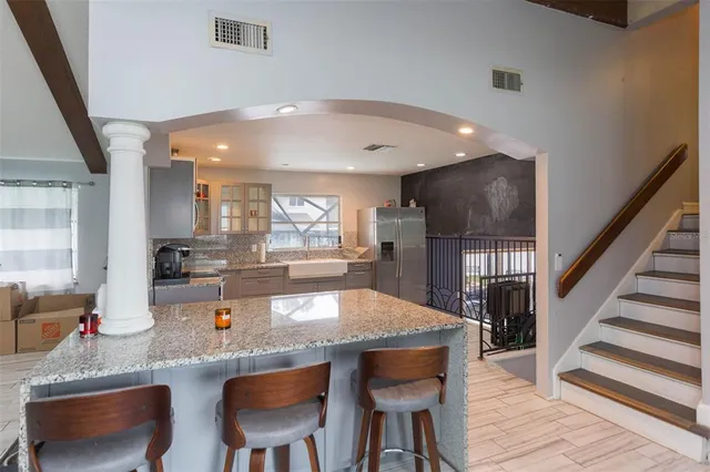 a kitchen with stainless steel appliances a dining table chairs and granite counter tops