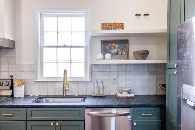 a kitchen with stainless steel appliances granite countertop a sink stove and cabinets