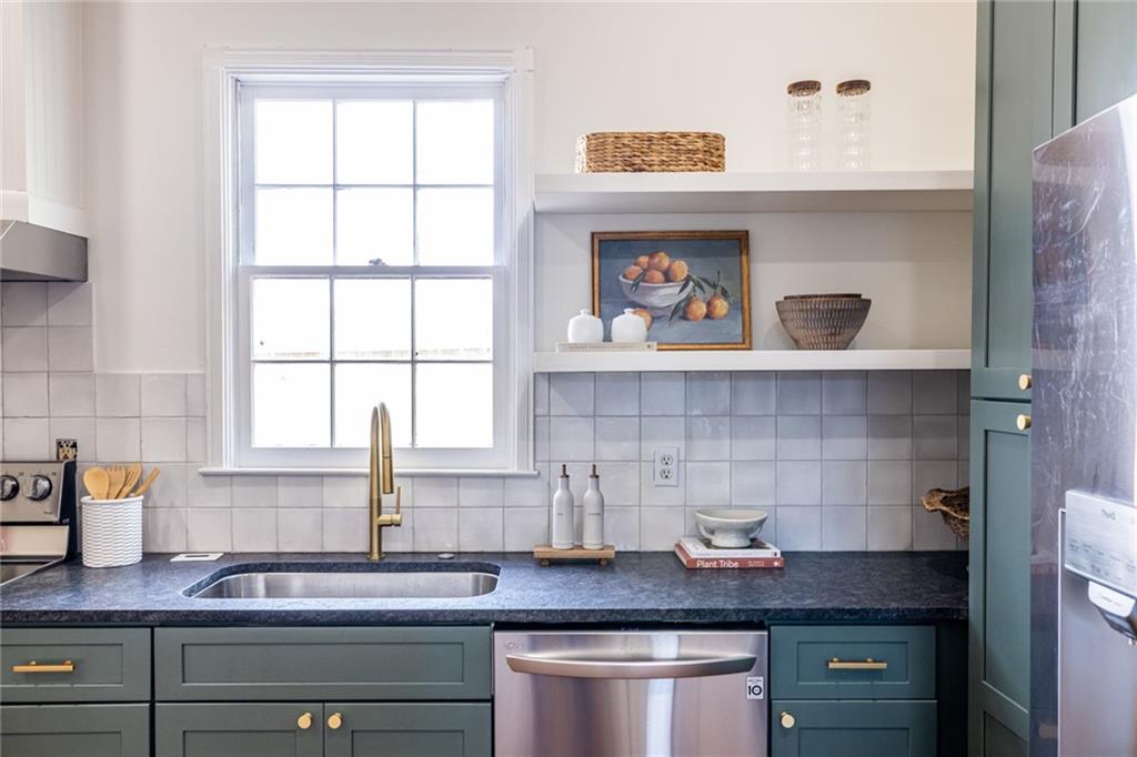 532 Broyles Street Southeast Atlanta, GA 30312 - Photo 18 of 37 a kitchen with stainless steel appliances granite countertop a sink stove and cabinets