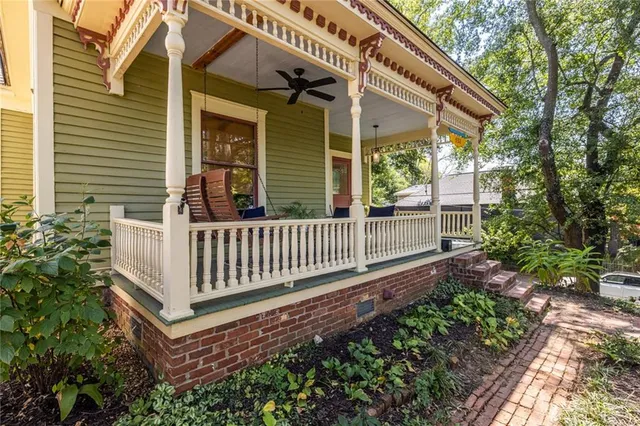 a view of a house with a small yard and wooden floor and fence