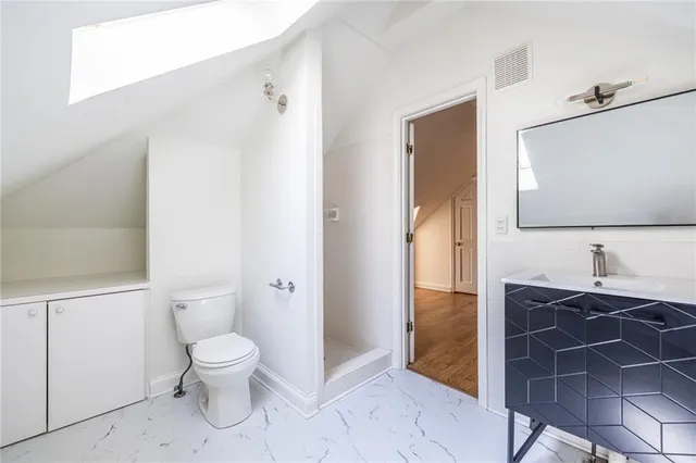 a bathroom with a toilet a sink and mirror