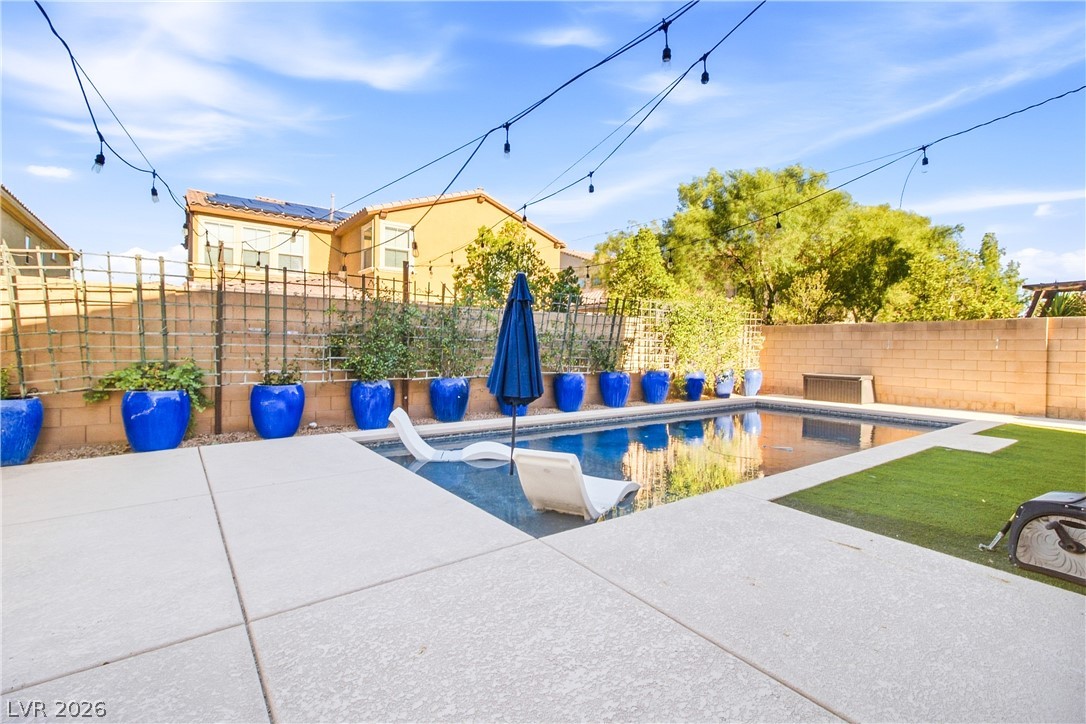 2182 Trivero Street Henderson, NV 89044 - Photo 40 of 50 An inviting backyard oasis showcases a sparkling in-ground pool framed by concrete decking and neat landscaping.