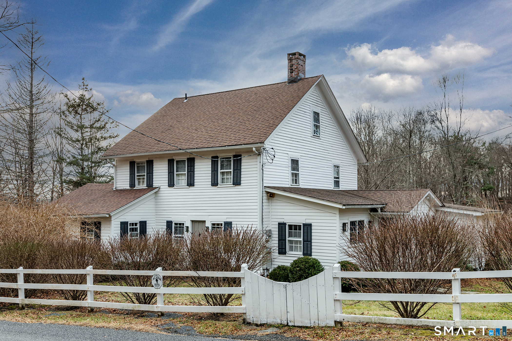 a view of a white house next to a yard