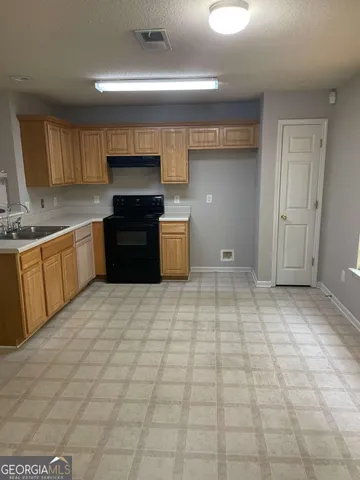 a kitchen with a stove top oven a sink and cabinets
