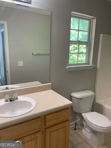 a bathroom with a sink toilet and a mirror