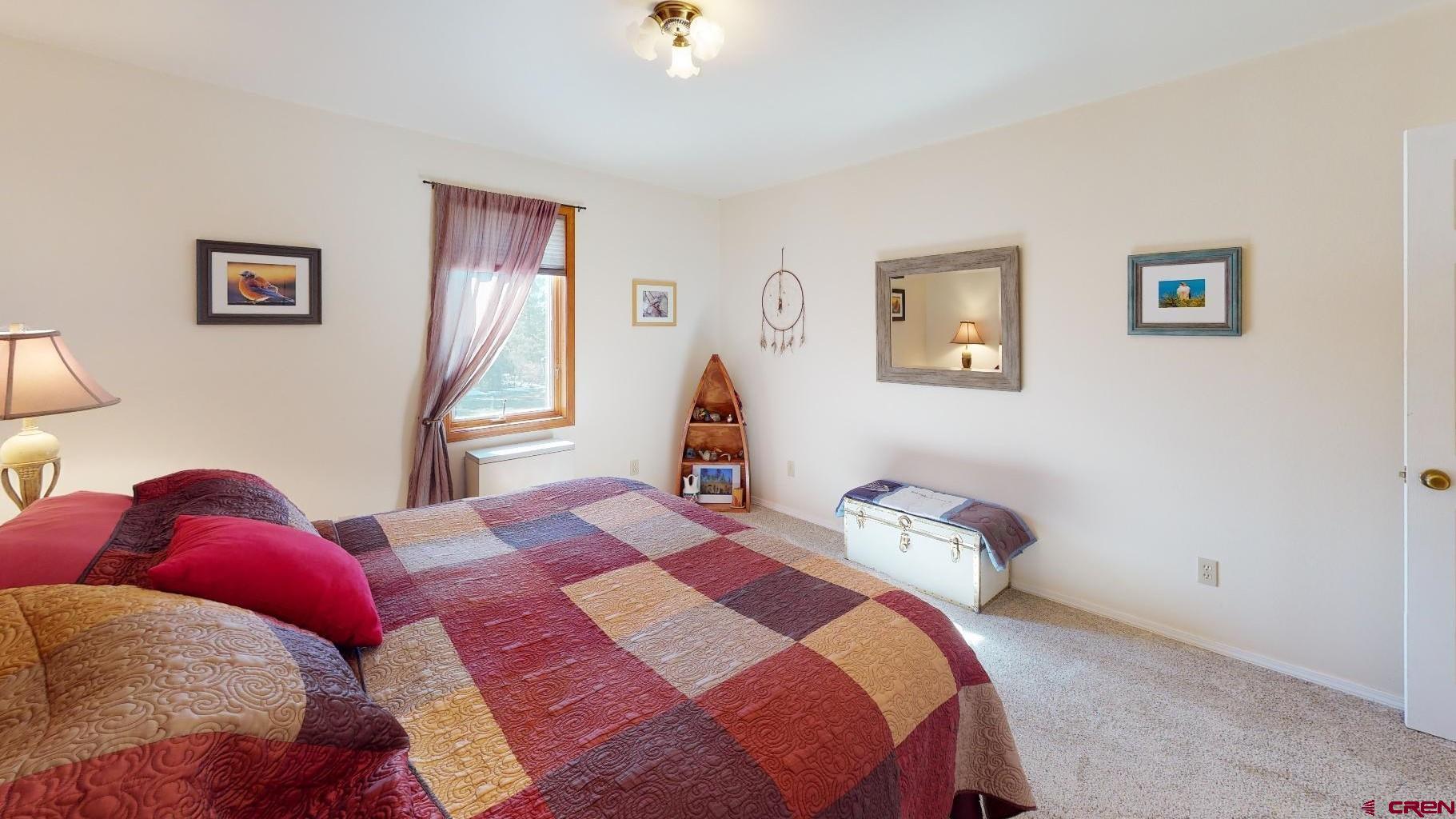 84 Ridge Road Durango, CO 81303 - Photo 17 of 33 a bedroom with a bed and a lamp on dresser