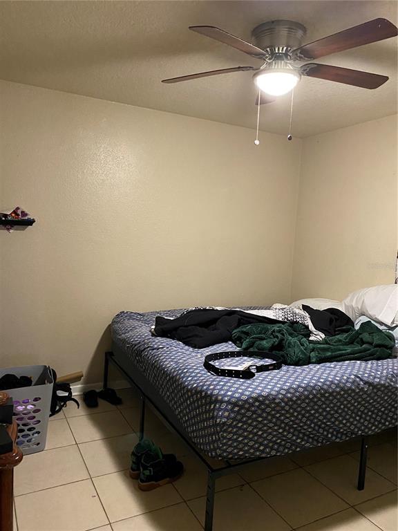 4207 Meadowbrook Avenue Orlando, FL 32808 - Photo 12 of 13 a bed sitting in a bedroom next to a lamp