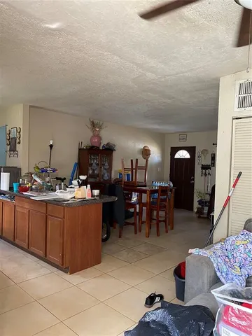 a living room with furniture a chandelier and a dining table