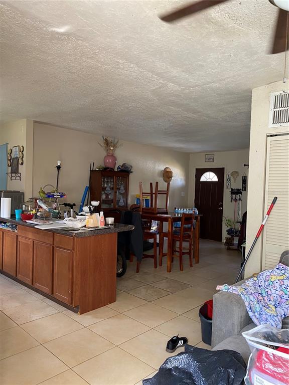 4207 Meadowbrook Avenue Orlando, FL 32808 - Photo 7 of 13 a living room with furniture a chandelier and a dining table