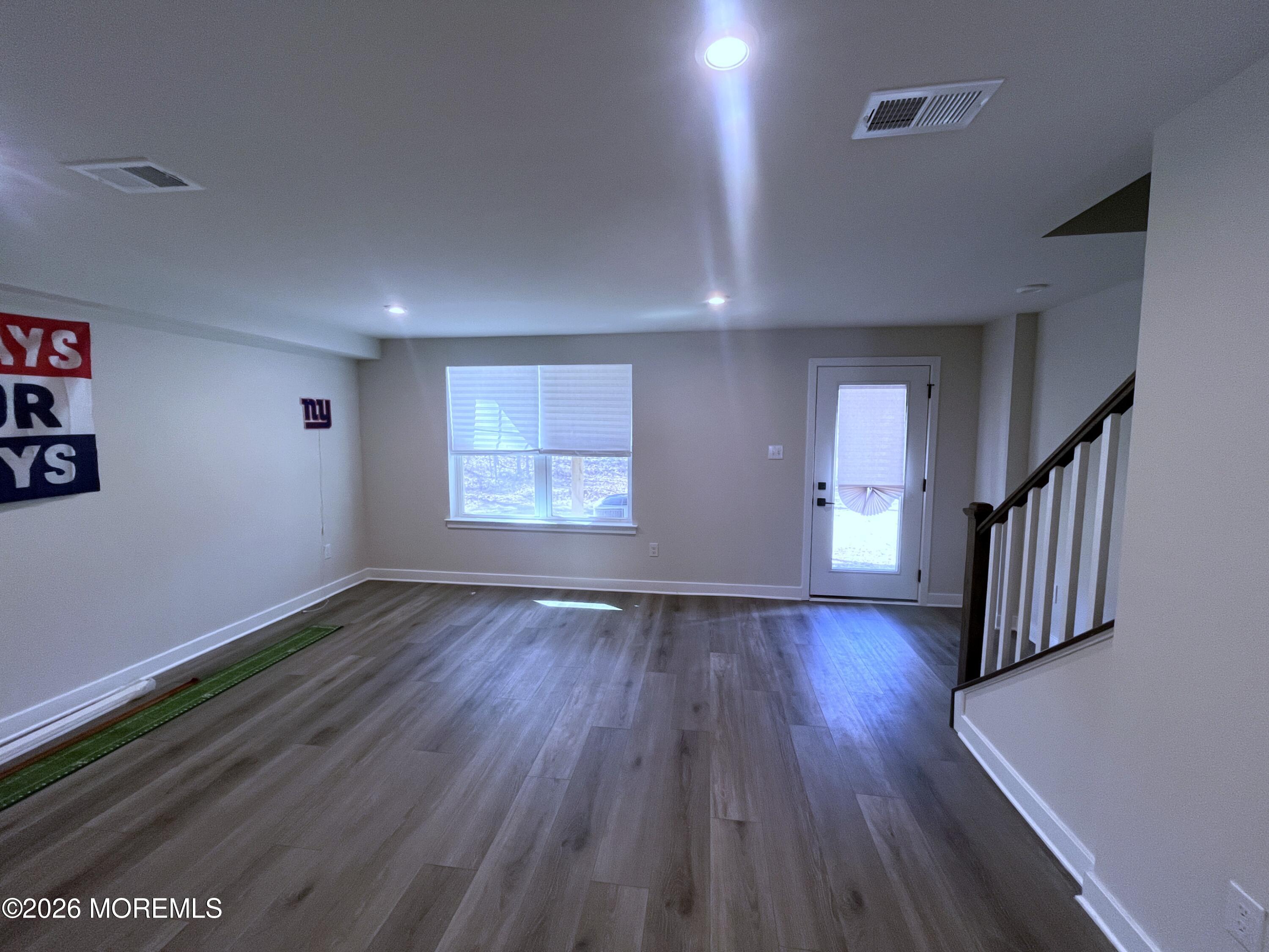 1 Halifax Road, Unit 1 Bayville, NJ 08721 - Photo 7 of 22 an empty room with wooden floor and windows