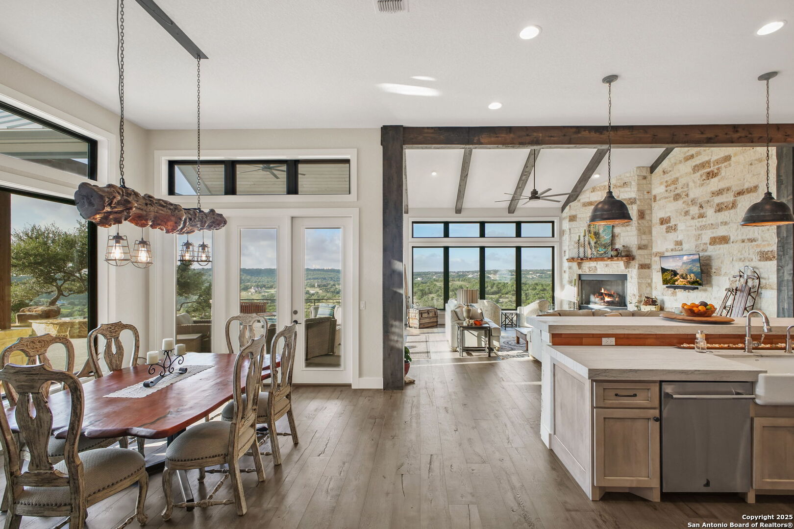1023 Comanche Ridge New Braunfels, TX 78132 - Photo 13 of 109 a open kitchen with stainless steel appliances granite countertop a stove a refrigerator a dining table and chairs with wooden floor