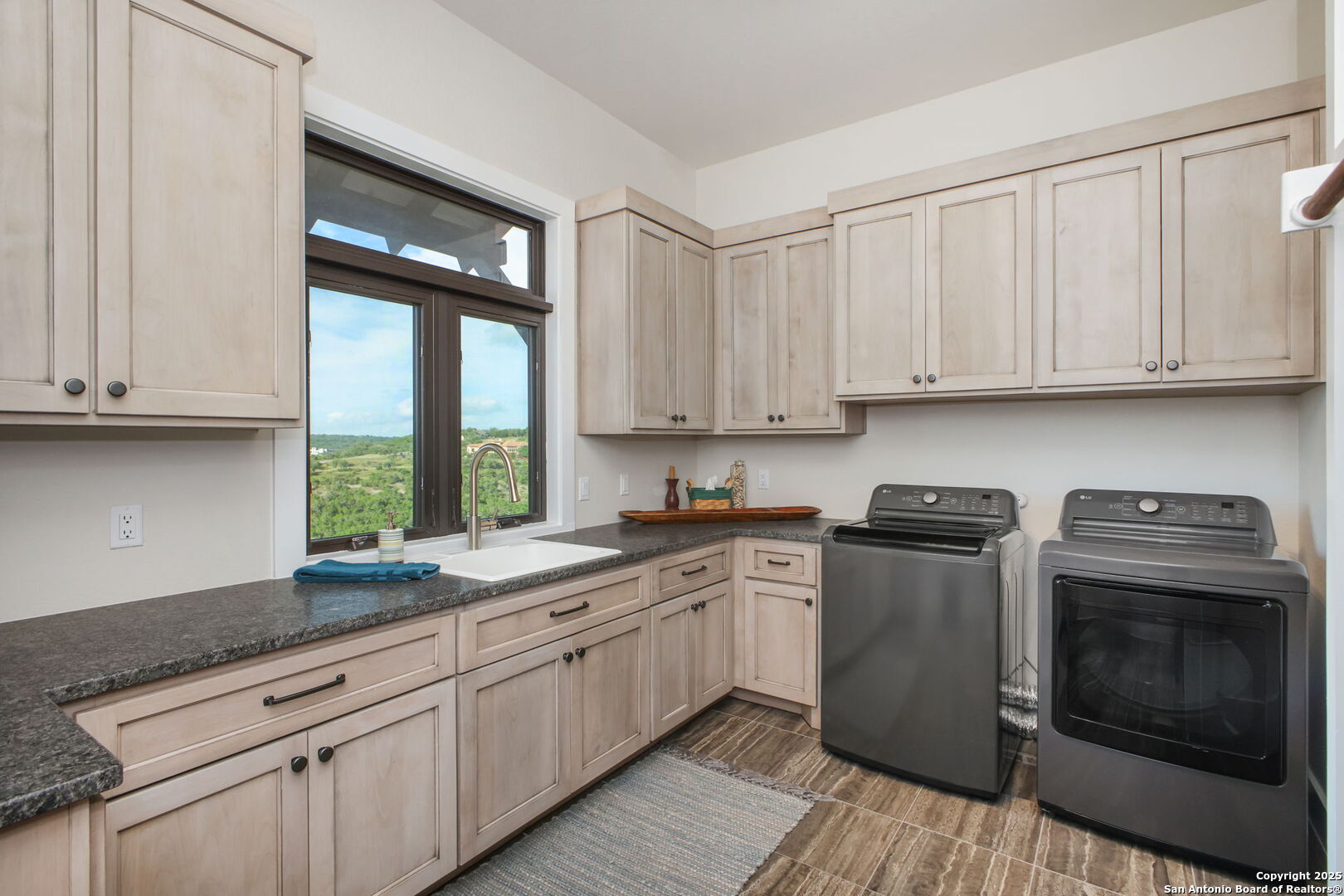 1023 Comanche Ridge New Braunfels, TX 78132 - Photo 27 of 109 a kitchen with granite countertop white cabinets stainless steel appliances a sink and a window