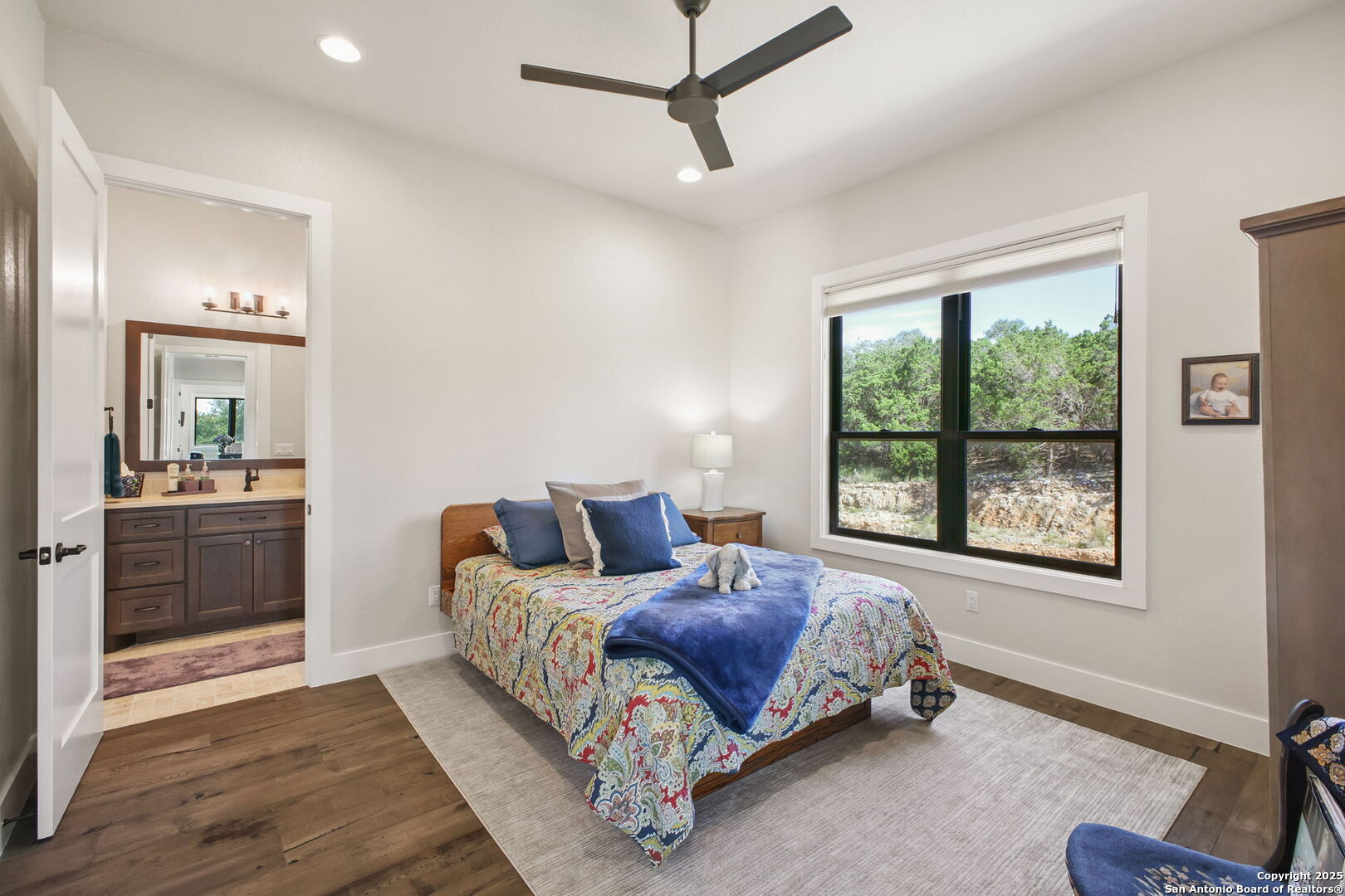 1023 Comanche Ridge New Braunfels, TX 78132 - Photo 51 of 109 a spacious bedroom with a bed a couch and a window