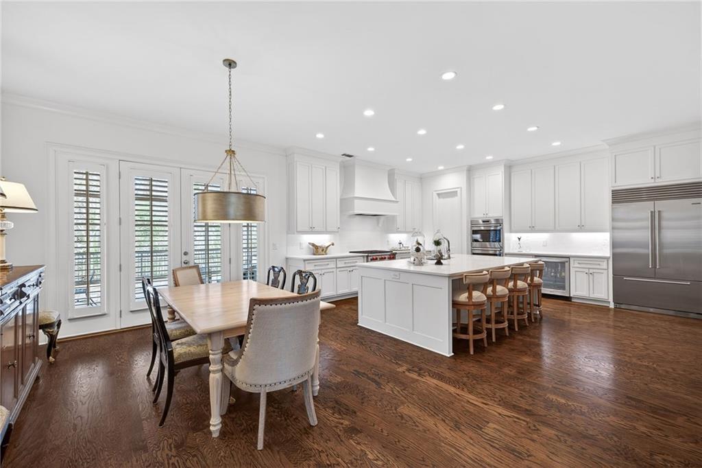4774 Wieuca Road Northeast Atlanta, GA 30342 - Photo 16 of 52 a kitchen with stainless steel appliances a dining table chairs stove refrigerator and cabinets