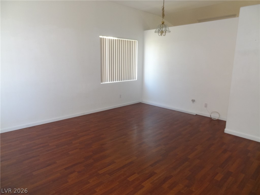 1199 Sunfire Street Henderson, NV 89014 - Photo 3 of 11 Spare room featuring dark wood-style floors and baseboards