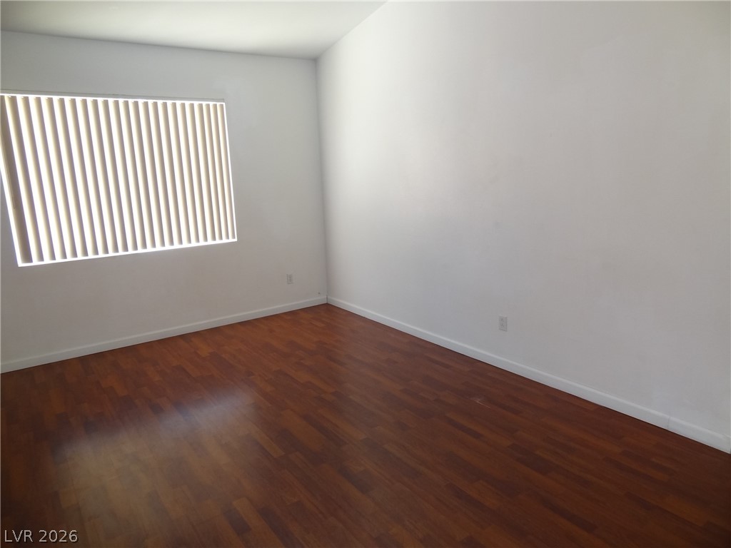 1199 Sunfire Street Henderson, NV 89014 - Photo 4 of 11 Unfurnished room with dark wood-style flooring and baseboards