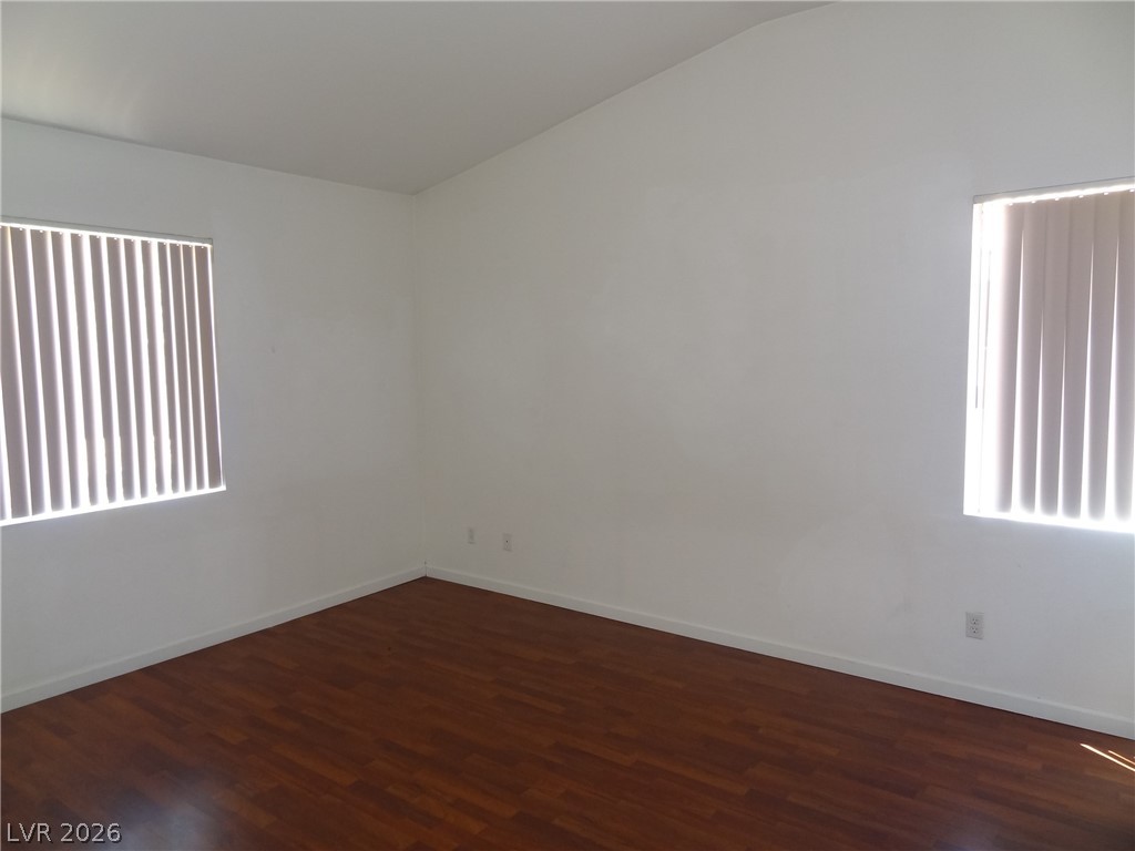1199 Sunfire Street Henderson, NV 89014 - Photo 6 of 11 Spare room with dark wood finished floors and lofted ceiling