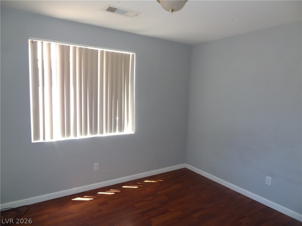 1199 Sunfire Street Henderson, NV 89014 - Photo 8 of 11 Spare room with baseboards and dark wood-style floors