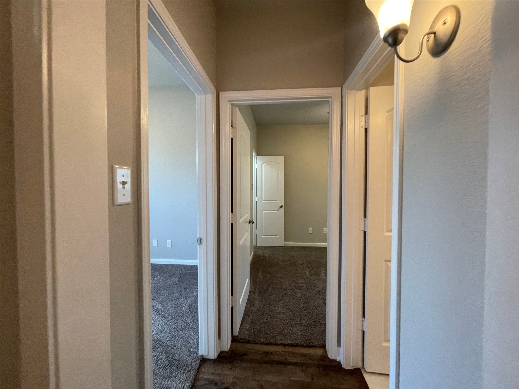 8113 Northgate Loop Temple, TX 76502 - Photo 12 of 35 Hallway with wood-finish flooring, light tan walls, and multiple door openings