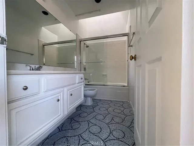 a spacious bathroom with a double vanity sink toilet mirror and shower