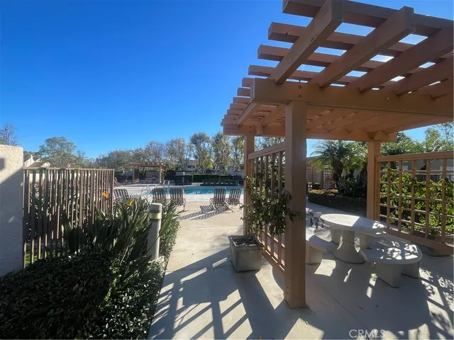 a view of a patio with table and chairs potted plants with wooden floor and fence
