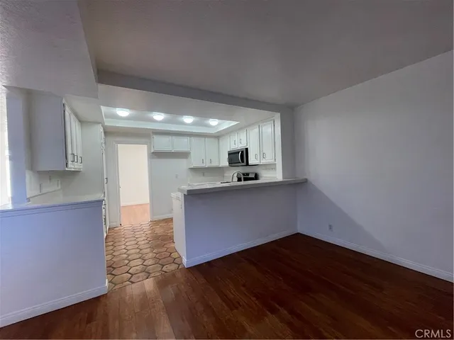 a kitchen with wooden floors and appliances