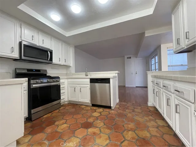 a kitchen with stainless steel appliances granite countertop a stove and a refrigerator