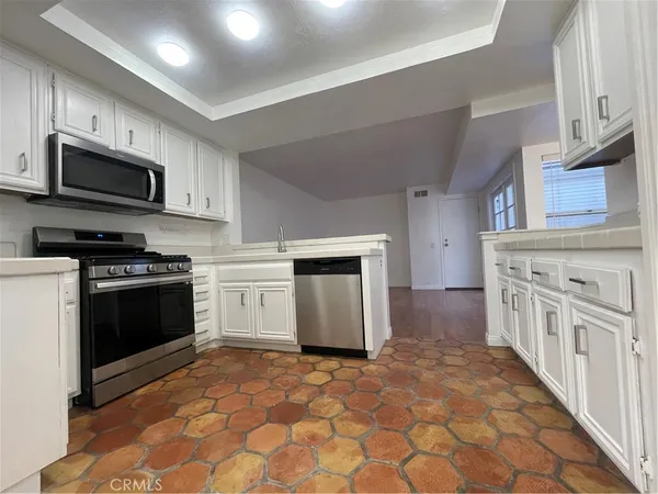 a kitchen with stainless steel appliances granite countertop a stove top oven a sink and a granite counter tops