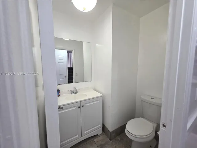 a bathroom with a toilet a sink a vanity and mirror