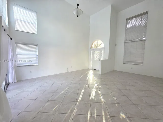 an empty room with windows and fireplace