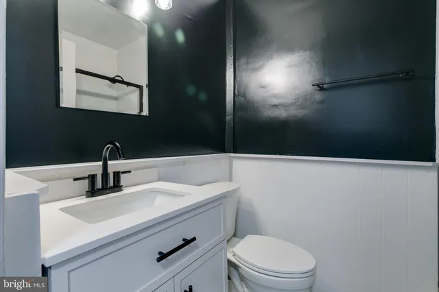 a bathroom with a sink a toilet a mirror and vanity