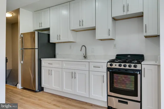a kitchen with cabinets appliances and wooden floor