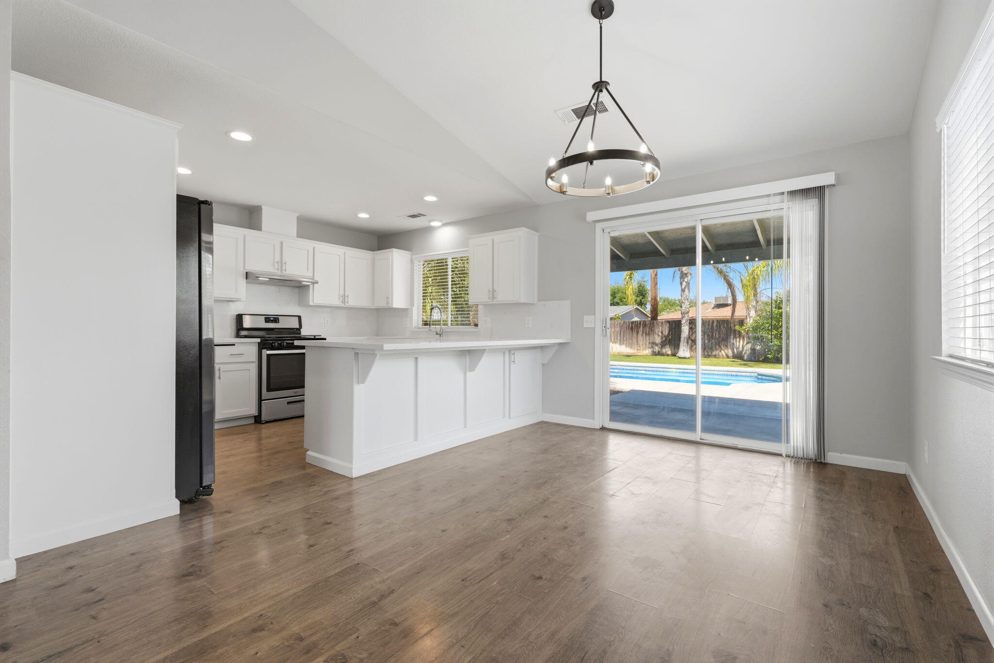 481 Katelyn Court Exeter, CA 93221 - Photo 22 of 33 a view of kitchen with stainless steel appliances granite countertop a stove top oven a refrigerator a sink and a dining table with wooden floor