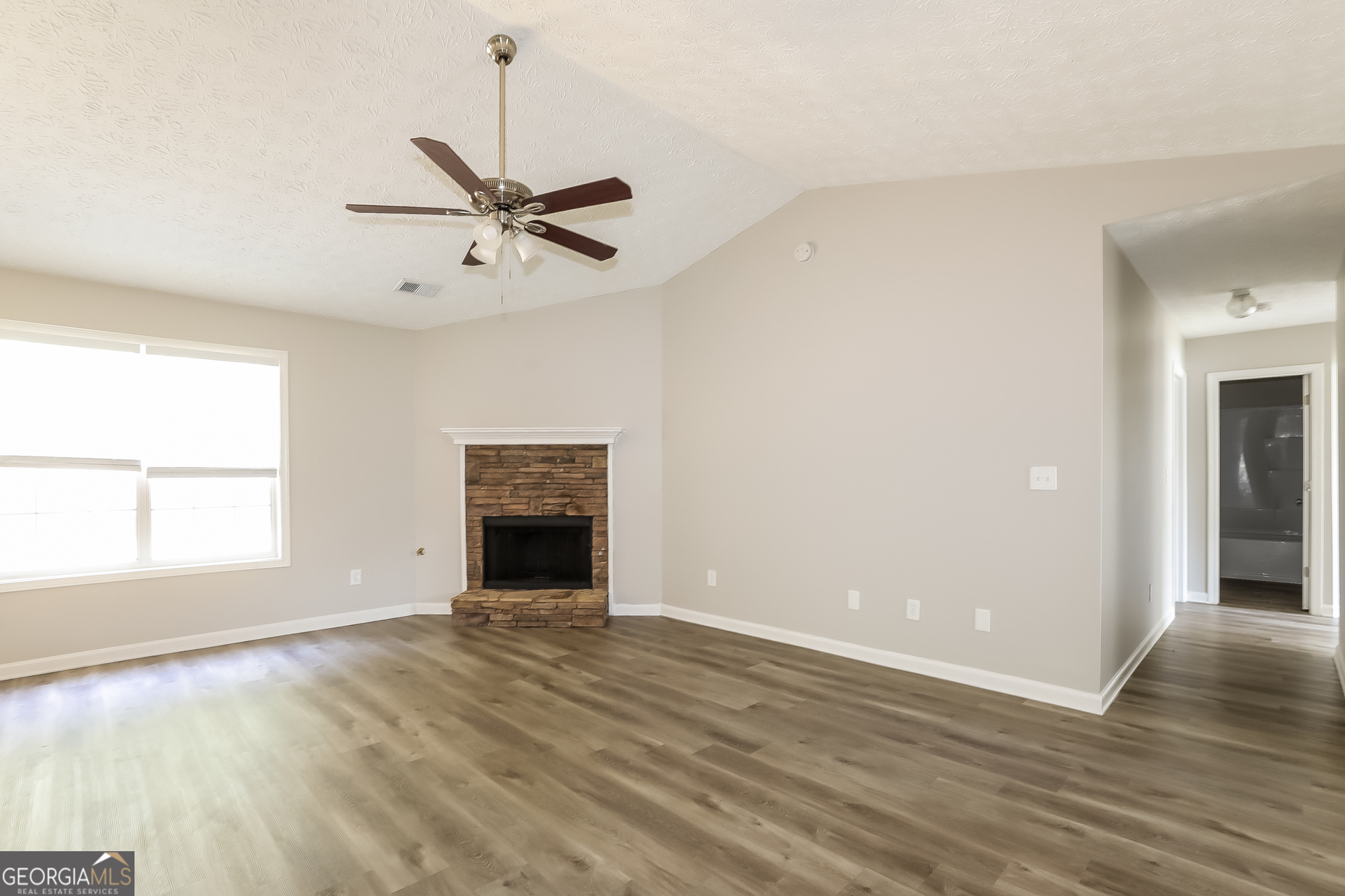 125 Waters Edge Drive Locust Grove, GA 30248 - Photo 2 of 16 an empty room with windows and fireplace
