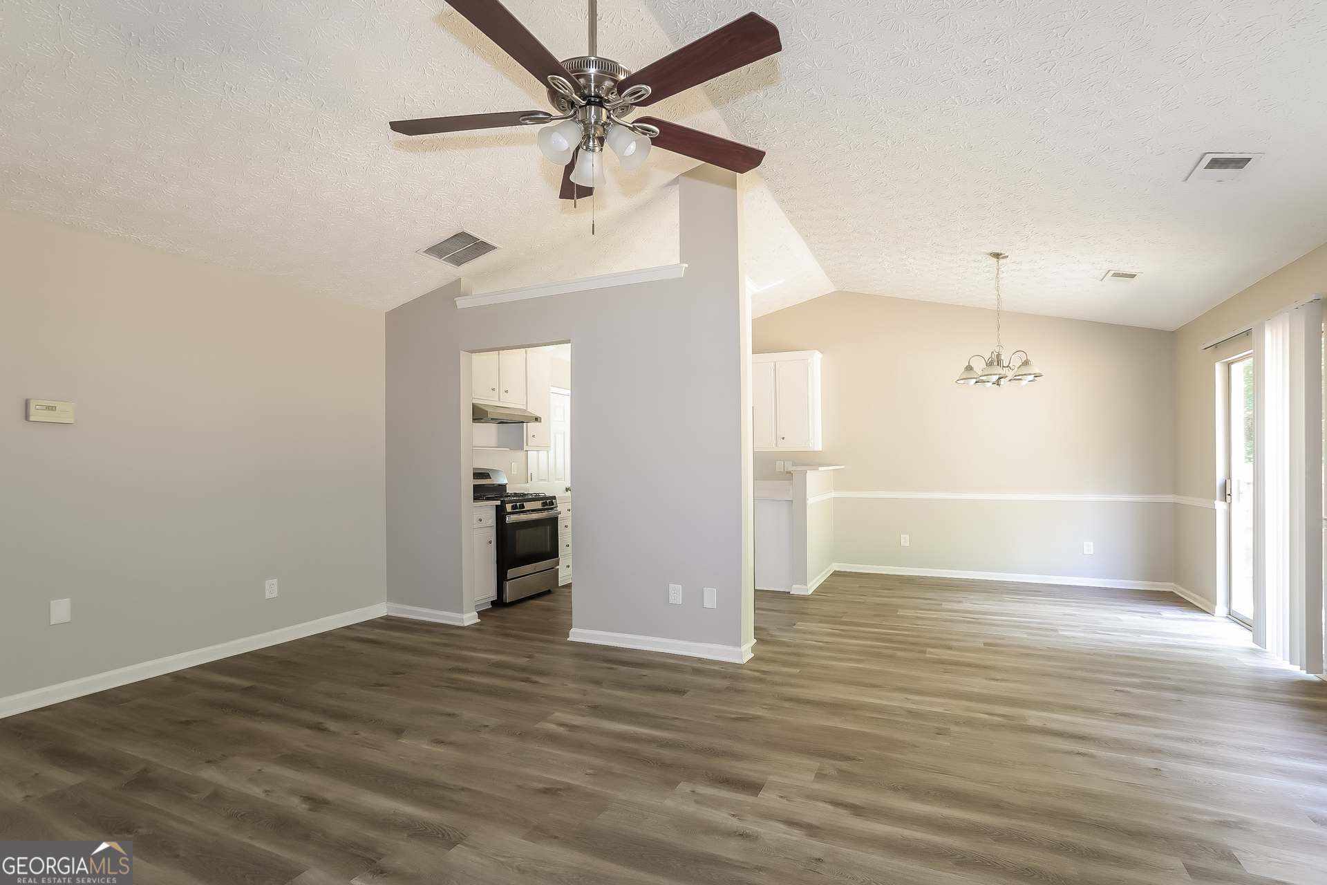 125 Waters Edge Drive Locust Grove, GA 30248 - Photo 3 of 16 an empty room with wooden floor fan and windows