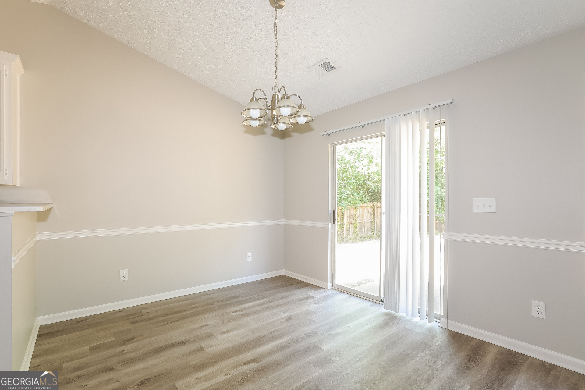 125 Waters Edge Drive Locust Grove, GA 30248 - Photo 4 of 16 an empty room with wooden floor and windows