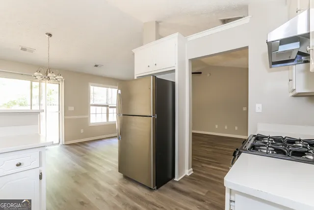 a kitchen with a refrigerator and a stove top oven