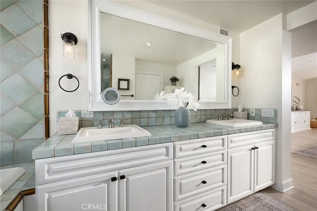 a bathroom with a granite countertop sink and a mirror