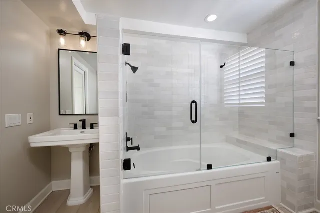 a bathroom with a tub sink and mirror