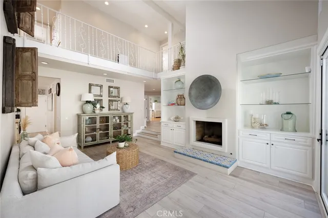 a living room with furniture a fireplace a rug cabinets and a window