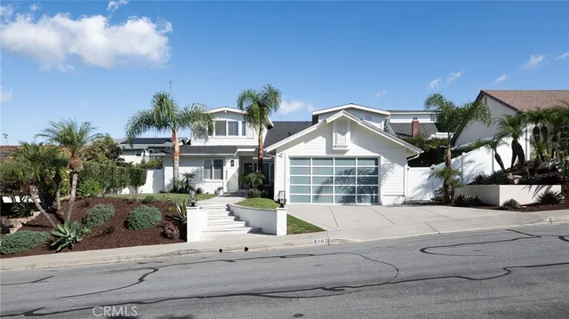a front view of a house with a yard and potted plants