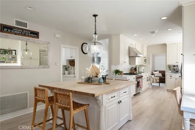 a kitchen with a table chairs and white cabinets